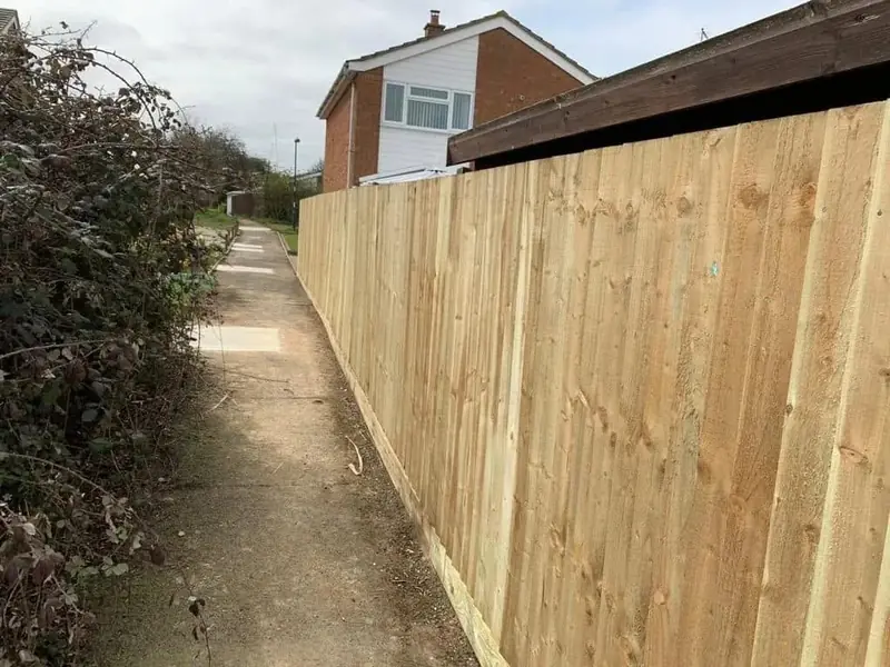 Freshly fitted feather edge fence beside a narrow footpath in Cross Hands
