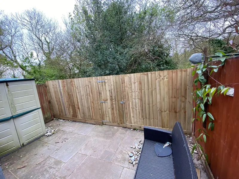 New feather edge fence around a back garden patio in West Cross, with a shed in the corner