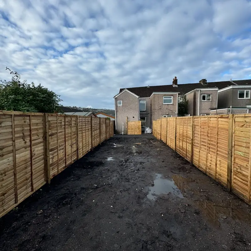Narrow back garden cleared to soil with new close board fencing on both sides